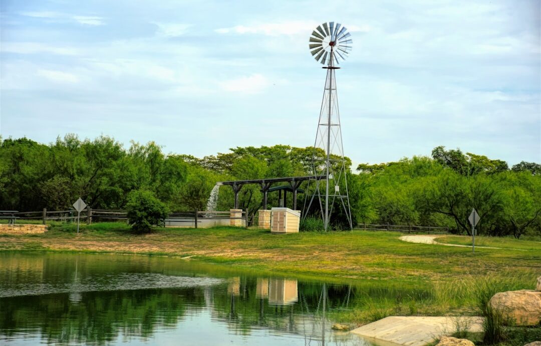 a windmill sitting on top of a lush green field